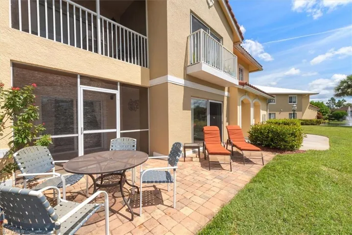 Patio / terrace featuring a patio area, outdoor dining space, a sunroom, and a lawn