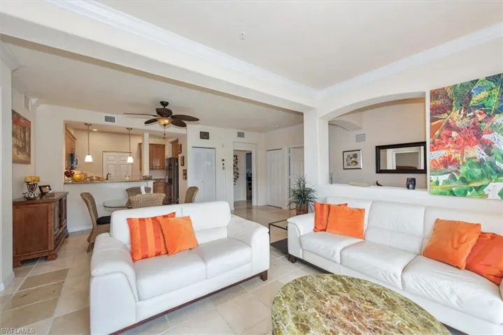 Living area featuring ornamental molding, ceiling fan, and light tile patterned floors
