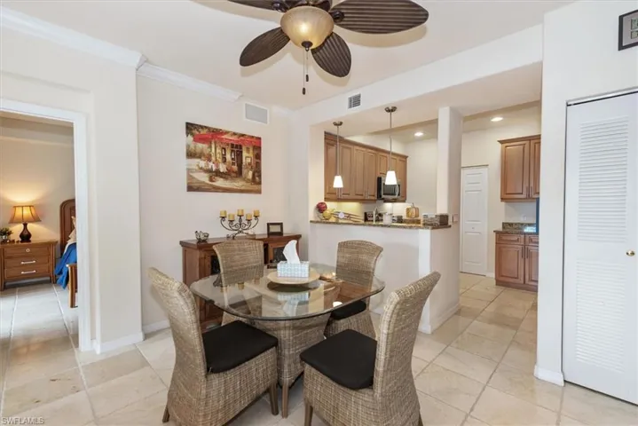 Dining area with ceiling fan and crown molding