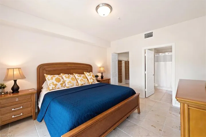 Bedroom featuring ensuite bathroom and light tile patterned flooring