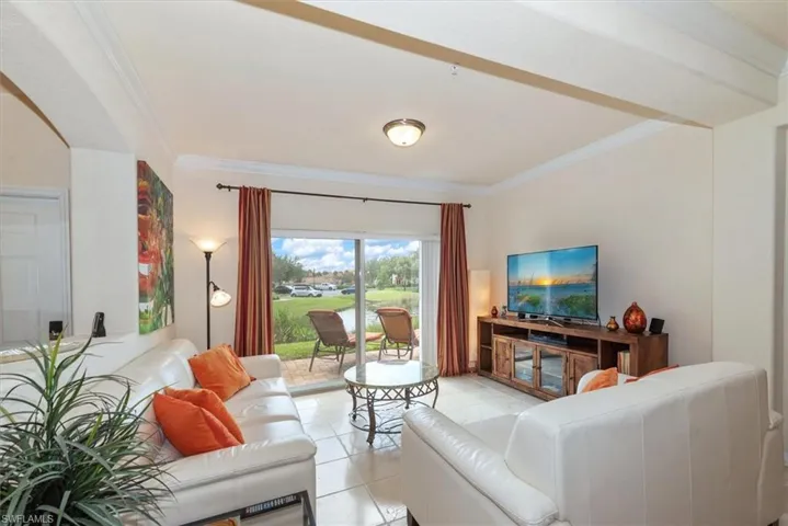 Living room with crown molding and light tile patterned floors