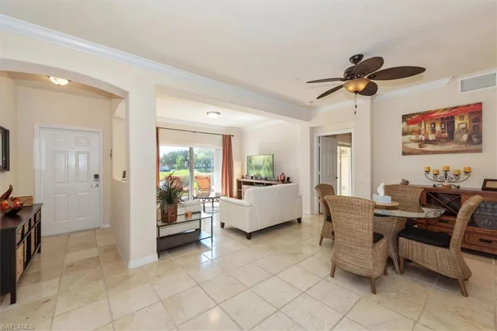 Dining room with arched walkways, crown molding, and ceiling fan