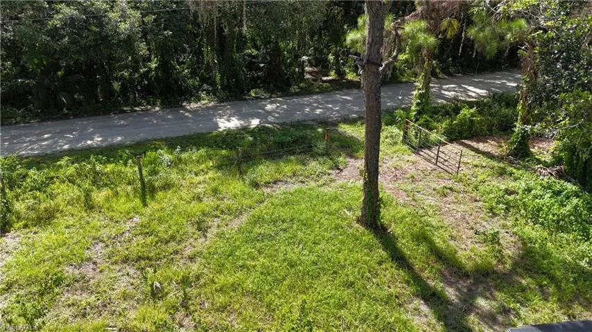View of subject property featuring a tree filled landscape