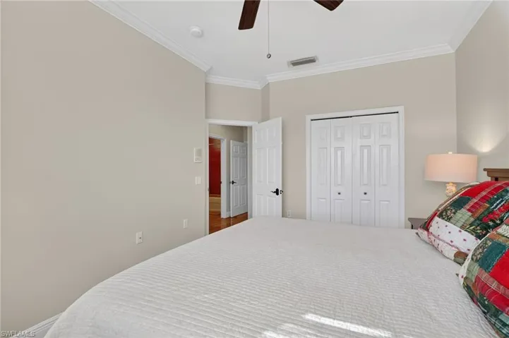 Bedroom featuring ornamental molding, a ceiling fan, and a closet