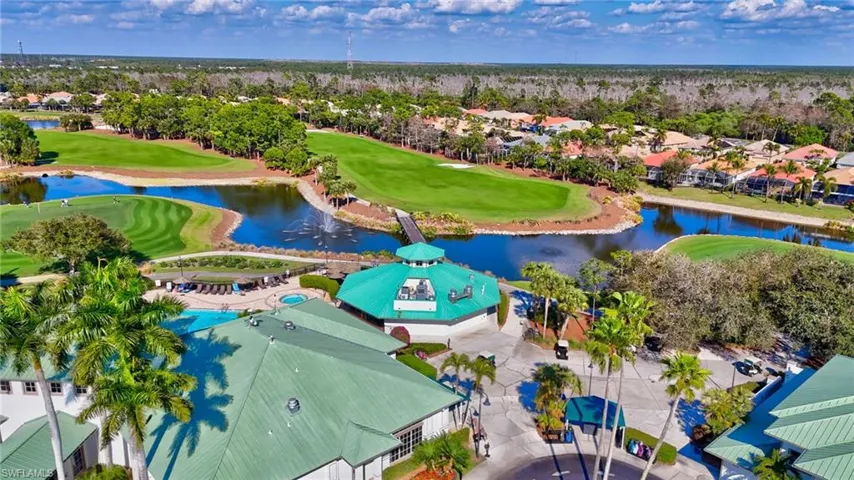 Aerial perspective of suburban area featuring a local golf course and a nearby body of water