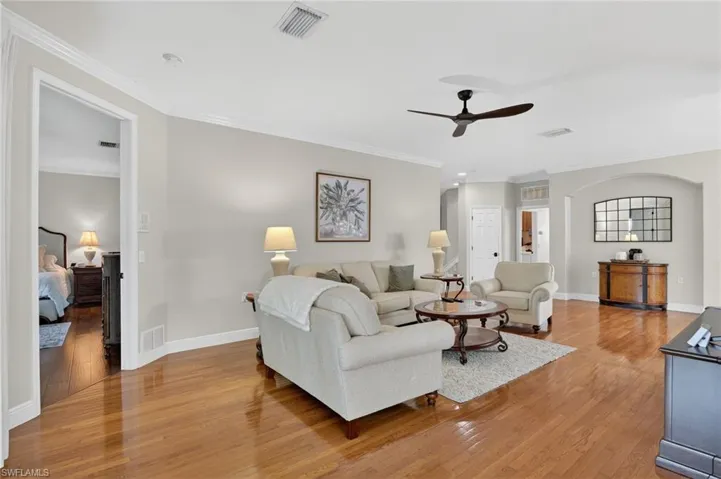Living area featuring crown molding, a ceiling fan, and light wood finished floors