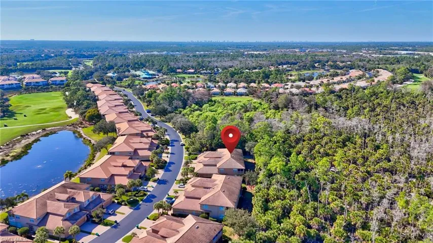Aerial perspective of suburban area with a large body of water and a golf course
