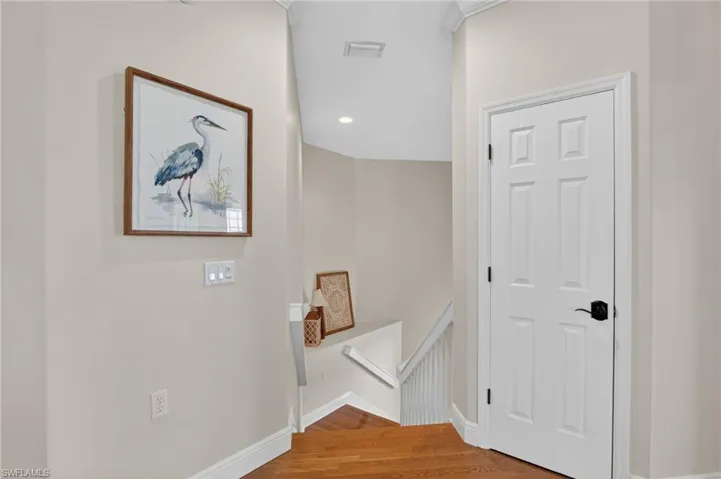 Corridor featuring an upstairs landing, wood finished floors, and recessed lighting