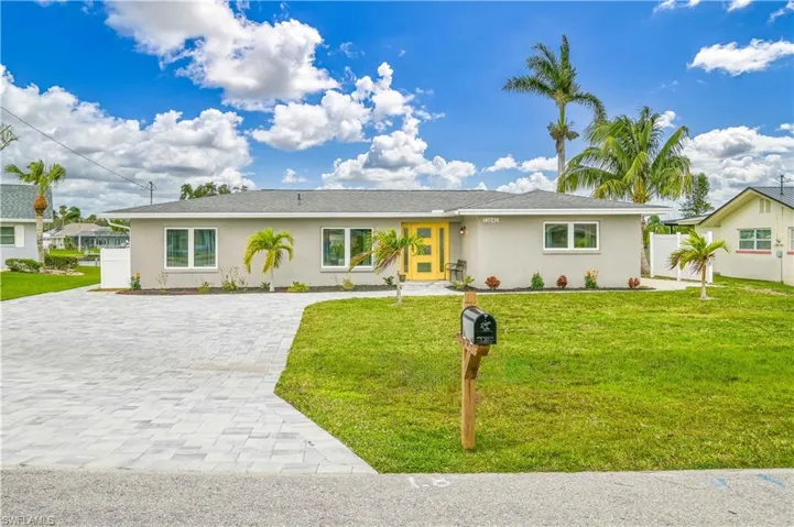 Ranch-style home featuring decorative driveway and stucco siding