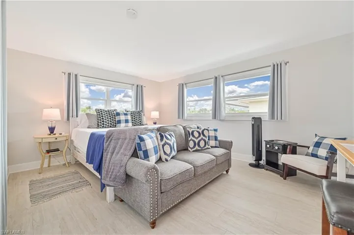 Bedroom featuring multiple windows and light wood-type flooring
