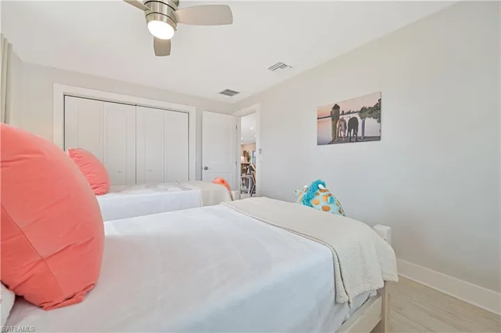 Bedroom with a closet, a ceiling fan, and light wood finished floors