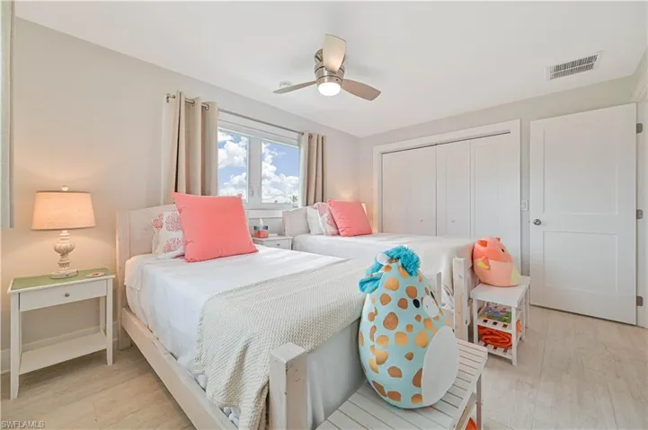 Bedroom with light wood-type flooring, a closet, and ceiling fan