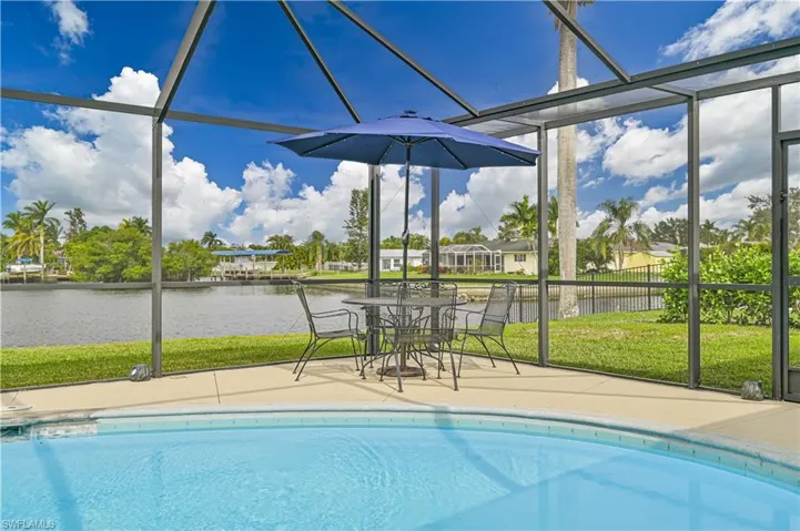 Outdoor pool featuring a water view, a lanai, and a patio