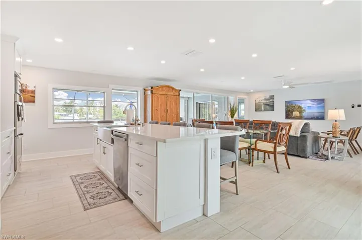 Kitchen with dishwasher, healthy amount of natural light, an island with sink, light countertops, and recessed lighting