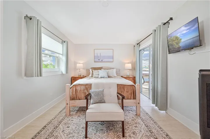 Bedroom with multiple windows, access to outside, and light wood-type flooring