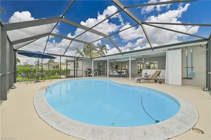 Swimming pool featuring a patio area, outdoor dining space, a ceiling fan, and a lanai