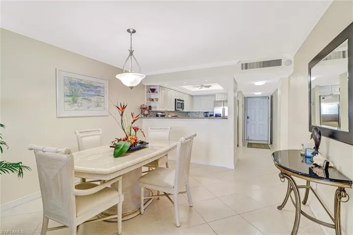 Dining space featuring ornamental molding and light tile patterned floors