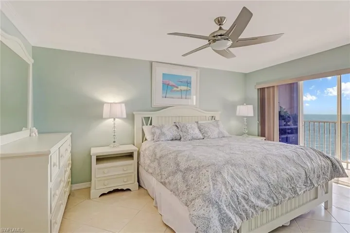 Bedroom featuring access to exterior, ceiling fan, a water view, and light tile patterned floors
