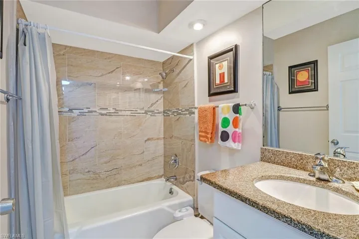 Bathroom featuring shower / bathtub combination with curtain and vanity