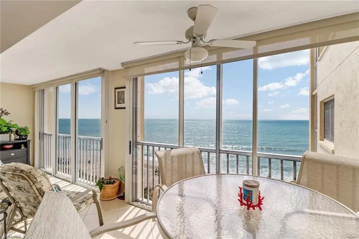 Sunroom / solarium featuring a water view, expansive windows, and tile patterned flooring
