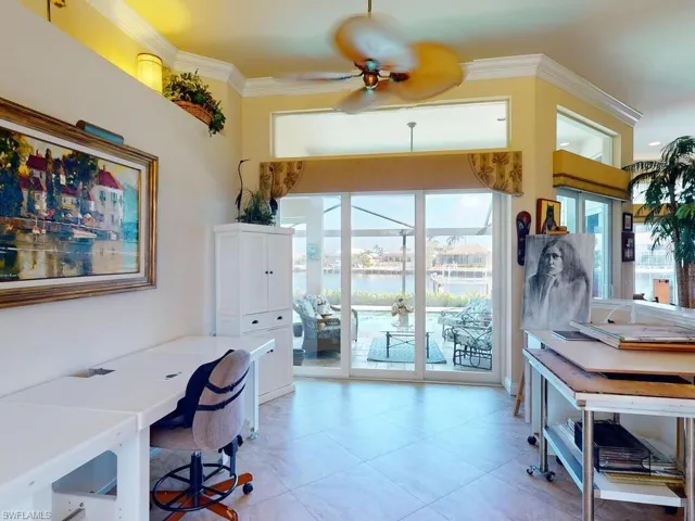 Office space with ornamental molding, a water view, light tile patterned floors, and ceiling fan