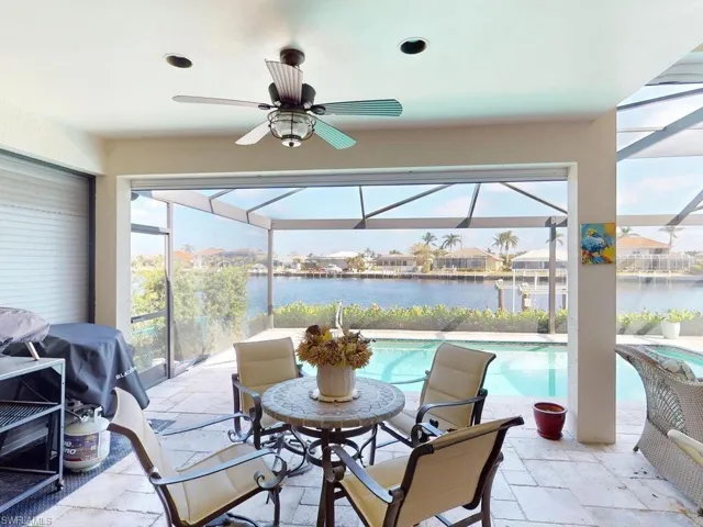 View of patio / terrace with a lanai, a water view, and ceiling fan