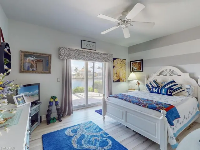 Bedroom with ceiling fan, light wood-type flooring, and access to exterior
