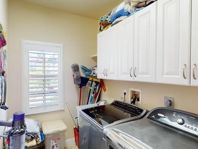Washroom with washer and dryer and cabinets