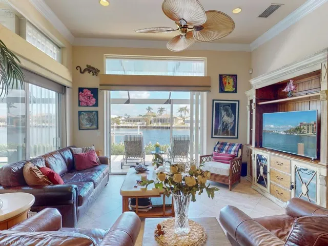 Living room with crown molding, a healthy amount of sunlight, and ceiling fan