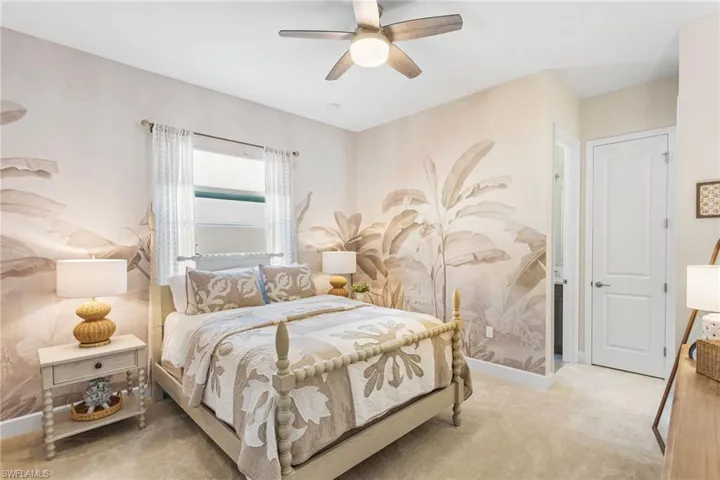 Bedroom with a ceiling fan and light colored carpet