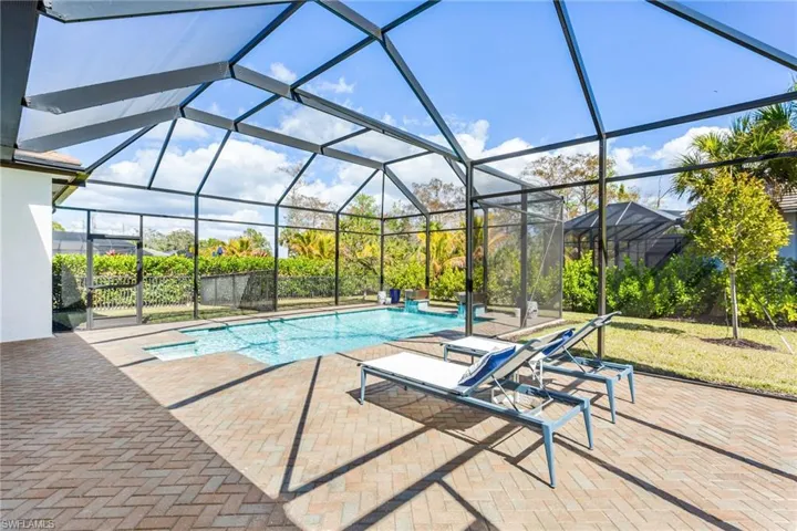 Swimming pool featuring a patio area, a lanai, and a sunroom