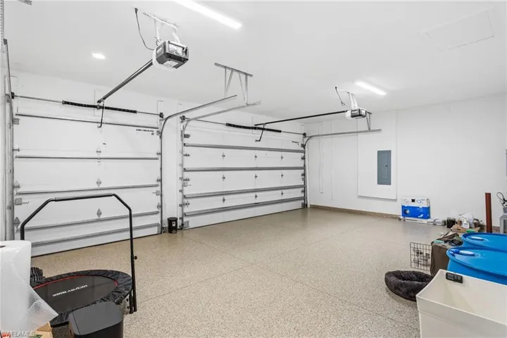Garage featuring electric panel and a garage door opener