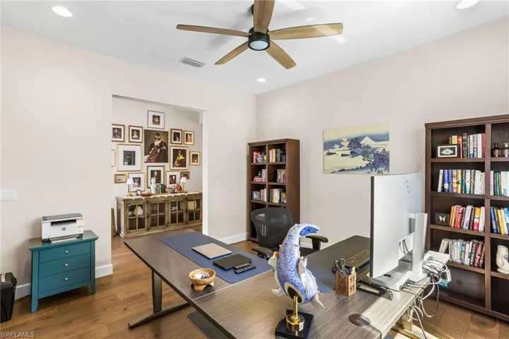 Home office with hardwood / wood-style flooring, a ceiling fan, and recessed lighting