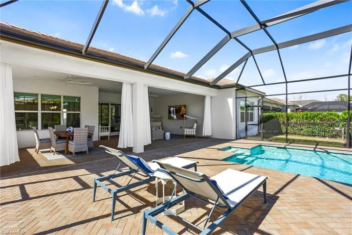Swimming pool featuring a sunroom, a patio, a lanai, and outdoor dining space