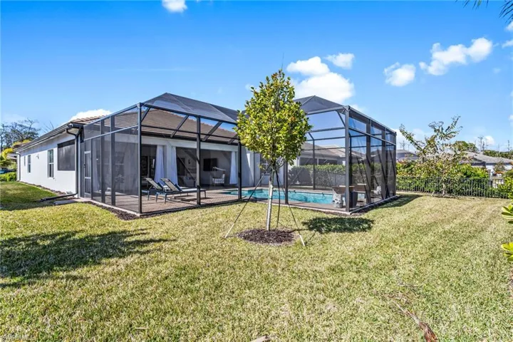 Back of property with a sunroom, a patio area, and glass enclosure