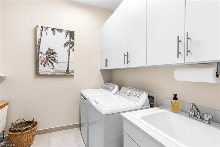 Laundry area featuring washing machine and clothes dryer and cabinet space