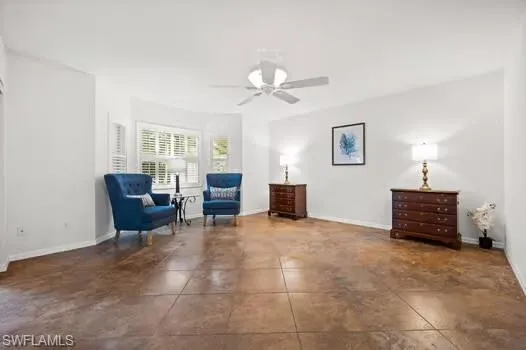 Living area with ceiling fan and dark tile patterned flooring