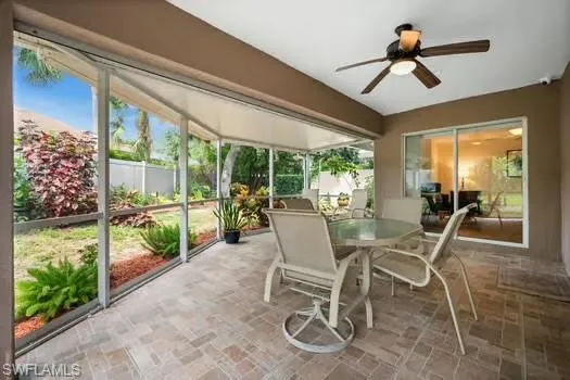 Sunroom / solarium with a ceiling fan and outdoor dining space