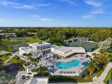Drone / aerial view of a pool and a heavily wooded area