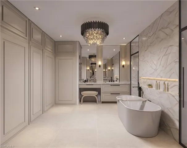 Full bathroom with a soaking tub, vanity, tile walls, stone wall, and a chandelier