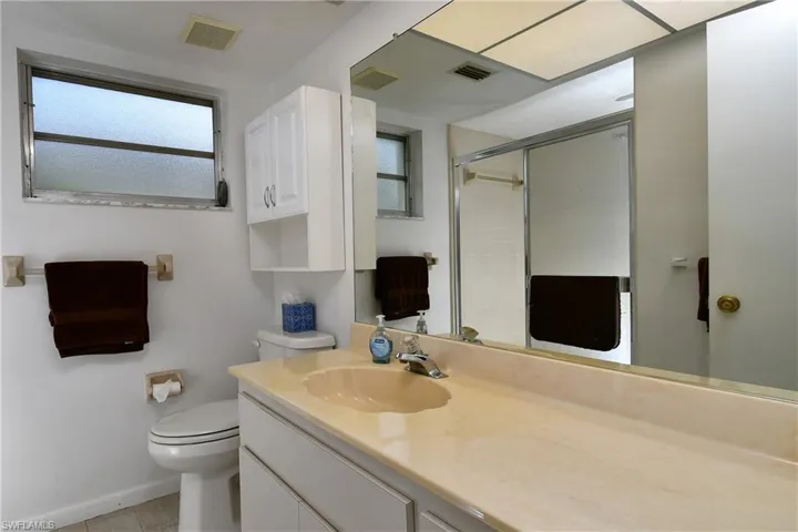 Bathroom with tile flooring, large vanity, and toilet