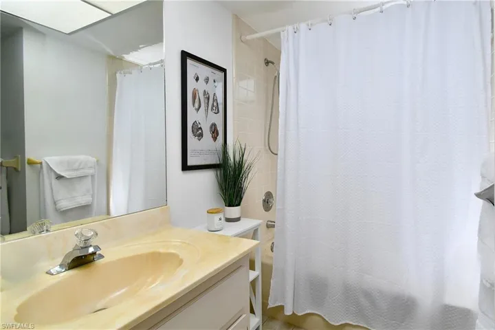 Bathroom with vanity with extensive cabinet space and shower / bath combo