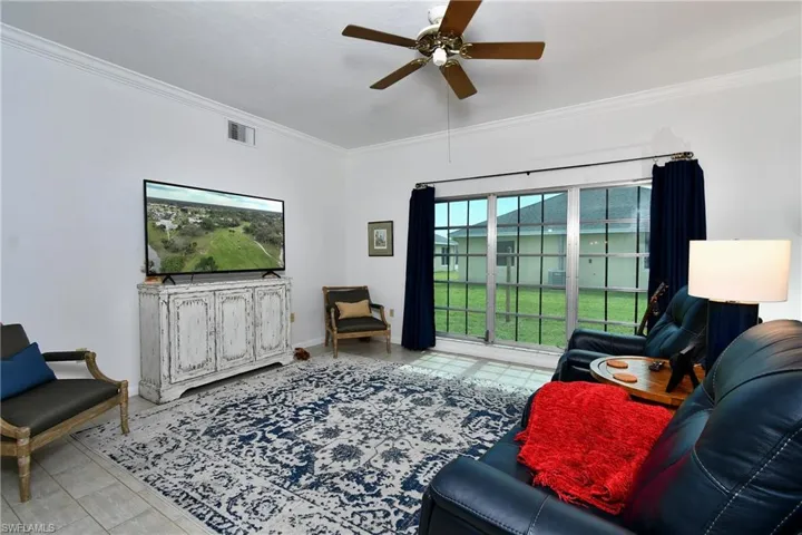 Living room featuring ornamental molding and ceiling fan