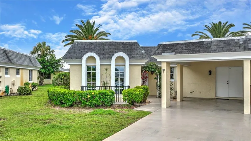 View of front of house with a carport and a front yard
