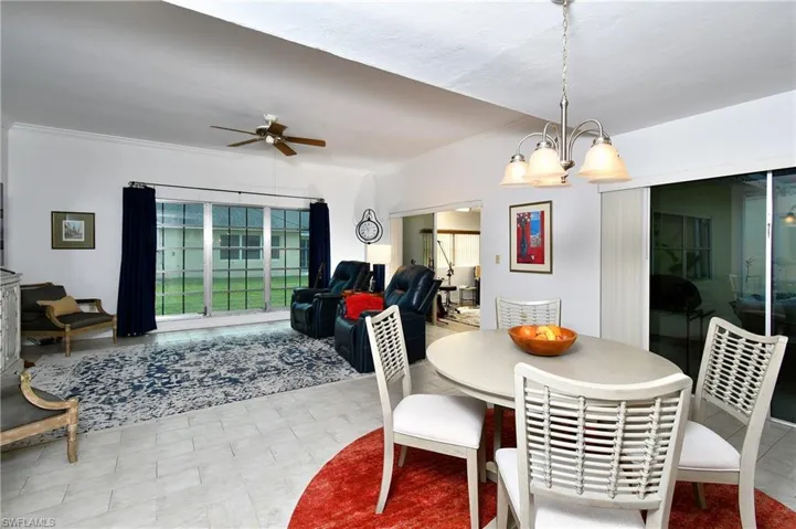 Tiled dining area and ceiling fan with notable chandelier