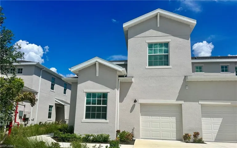 Traditional-style home with stucco siding, an attached garage, and concrete driveway