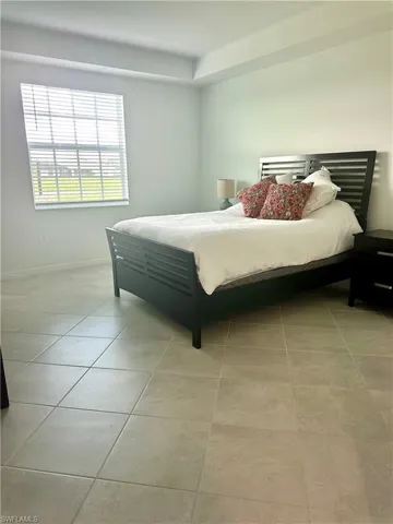 Bedroom featuring light tile patterned floors and baseboards