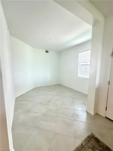 Unfurnished room with light tile patterned floors and baseboards