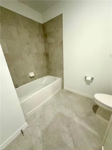Bathroom featuring toilet and light tile patterned flooring