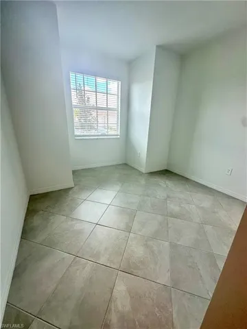 Empty room featuring baseboards and light tile patterned floors